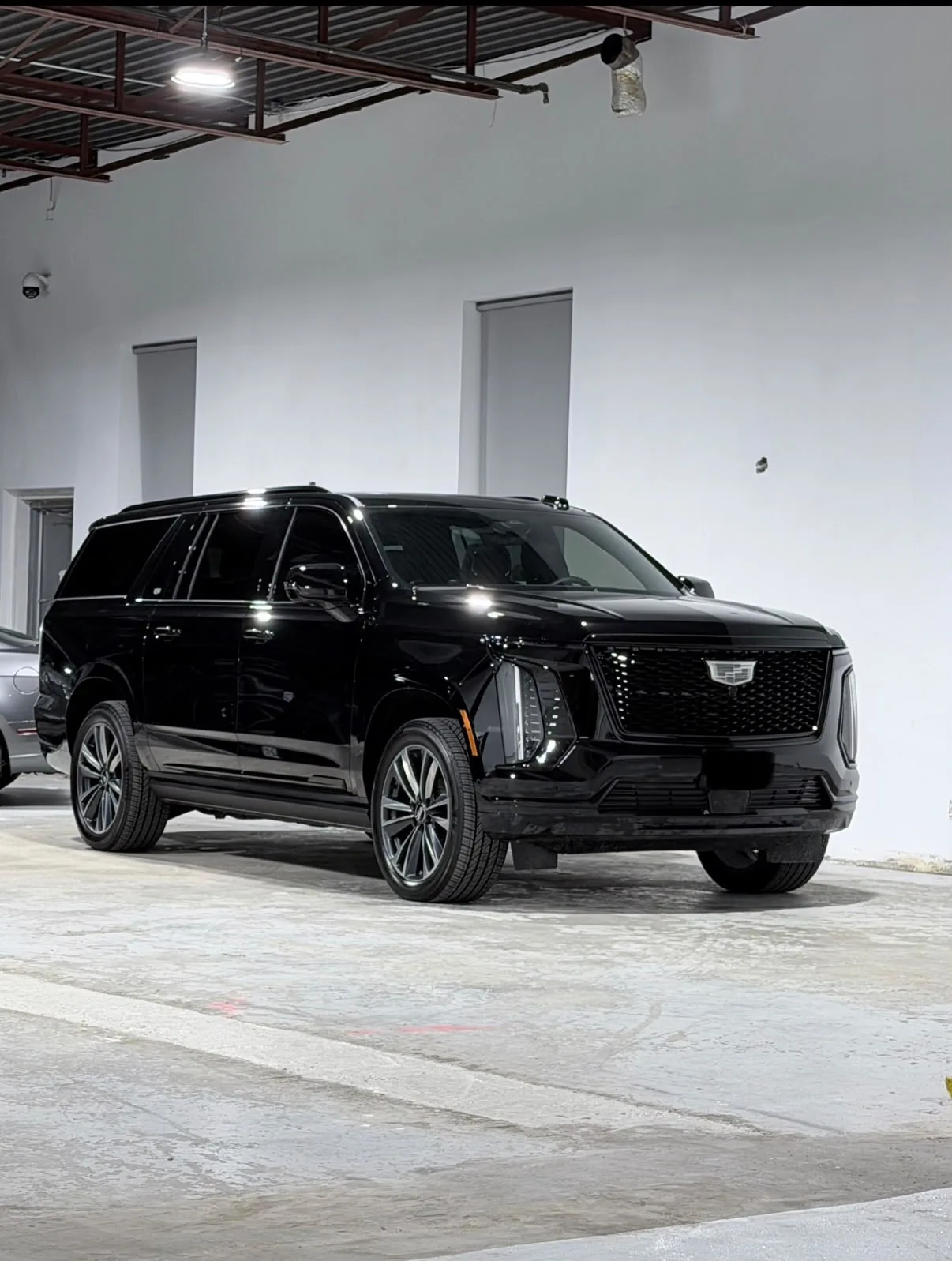 Black Cadillac Escalade ESV in a bright garage