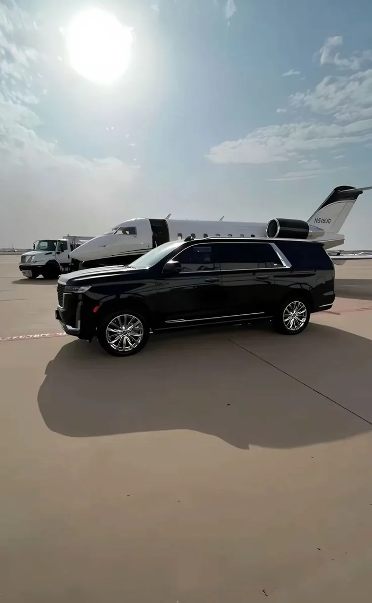 Cadillac Escalade ESV on an airport apron beside a private jet
